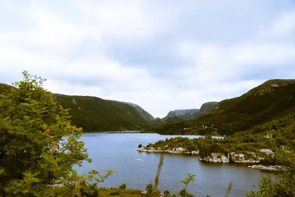 A picture of a lake in norway with big mountains.