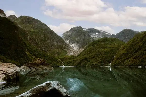 A picture of a clean, reflecting lake in norway with big mountains.